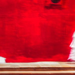 two nuns in white walking in front of red wall